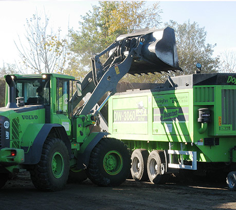 Baufahrzeuge beim Bearbeiten und Anliefern des Schuttmaterials